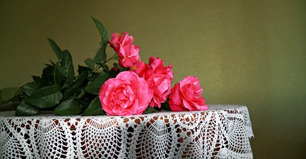 Bouquet of scarlet roses on a table — Stock Photo, Image