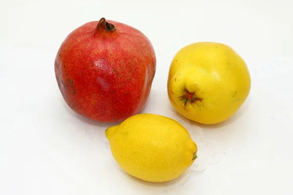 Quince, pomegranate, lemon on a white cloth — Stock Photo, Image