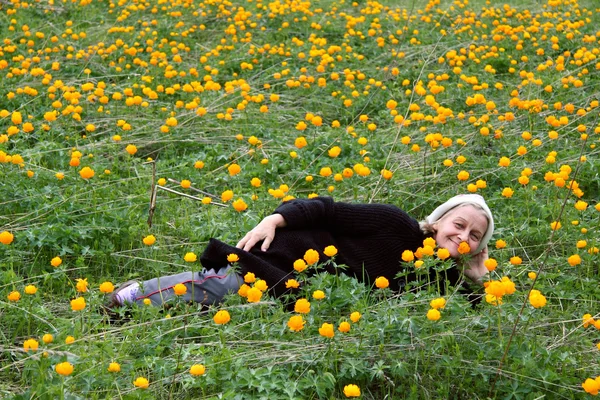 Mulher sênior sorridente em flores de campo — Fotografia de Stock