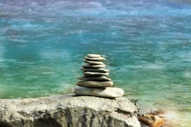 Taşlardan piramit, kumsalda serilmiş.