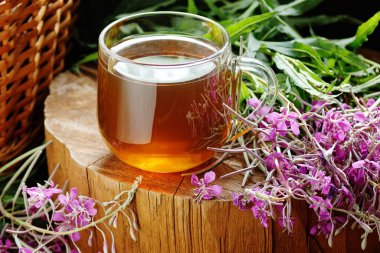 Söğüt bitkisi cam fincanda fermente edilmiş taze çiçekli bitki çayı ahşap arka planda, geleneksel Rus sıcak içeceği, yakın plan, naturopati ve doğal tıp konsepti