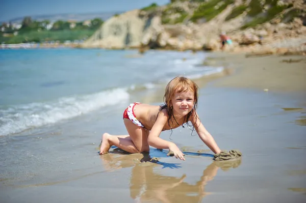 Mała dziewczynka gra na plaży — Zdjęcie stockowe