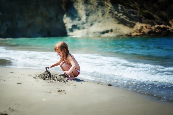 Menina brincando na areia — Fotografia de Stock