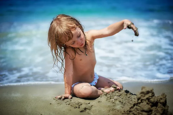 ? ute holka hraje v písku — Stock fotografie