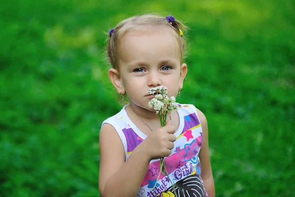 Liten flicka anläggning blommor — Stockfoto