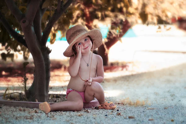 Lovely little girl in straw hat near tree — Stock Photo, Image