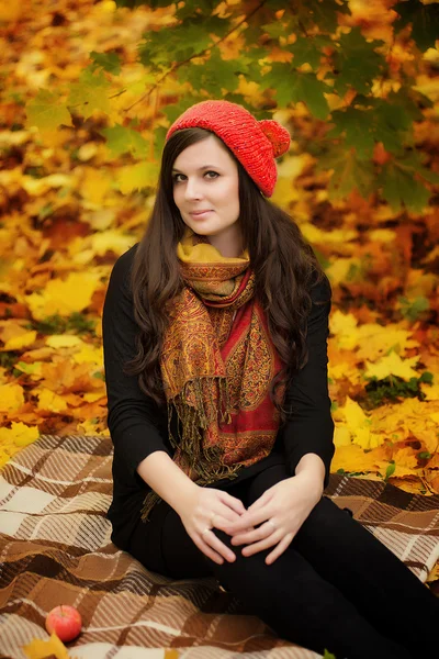 Mujer con gorra roja sentada en el parque —  Fotos de Stock