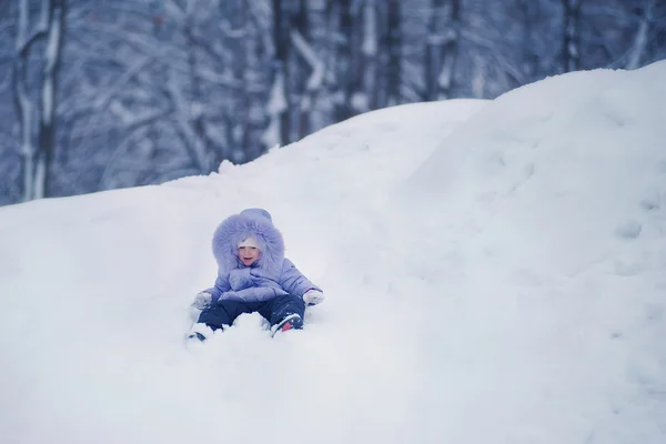 Flicka sitter i snö — Stockfoto