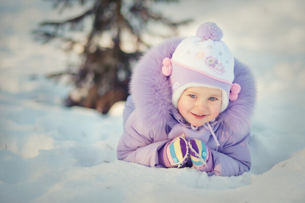 Девочка лежит на снегу
