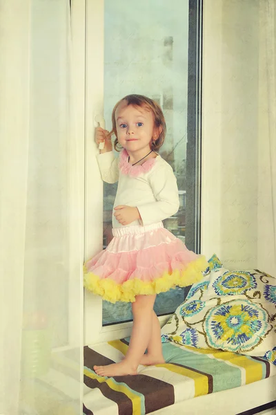 Mała dziewczynka otwiera okno — Zdjęcie stockowe