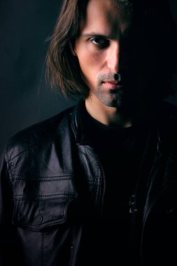 Karanlık bir arka planda gölgesi olan bir adamın portresi.