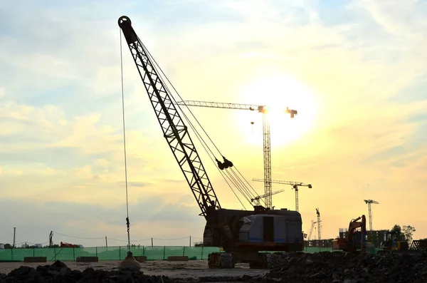 Crawler crane or dragline excavator with a heavy metal wrecking ball on a steel cable. Wrecking balls at construction sites. Dismantling and demolition of buildings and structures. Out of focus