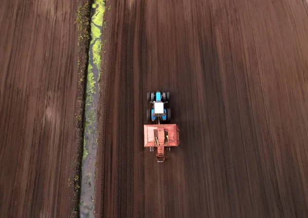 Peat Harvester Tractor on Collecting Extracting Peat. Mining and harvesting peatland. Area drained of the mire are used for peat extraction. Drainage and destruction of peat bogs.