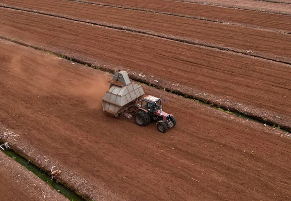 Peat Harvester Tractor on Collecting Extracting Peat. Mining and harvesting peatland. Area drained of the mire are used for peat extraction. Drainage and destruction of peat bogs.