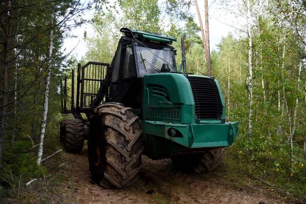 Crane forwarder machine during clearing of forested land. Wheeled harvester transports raw timber from felling site out. Harvesters, Forest Logging machines. Forestry forwarder on deforestation.