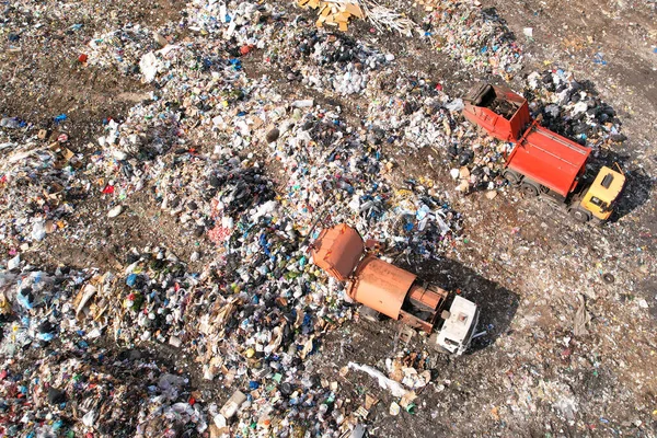 Garbage truck unloads rubbish in landfill. Landfill waste disposal. Garbage dump with waste plastic and polyethylene. Greenhouse gas emissions and methane emissions. Environmental protection.