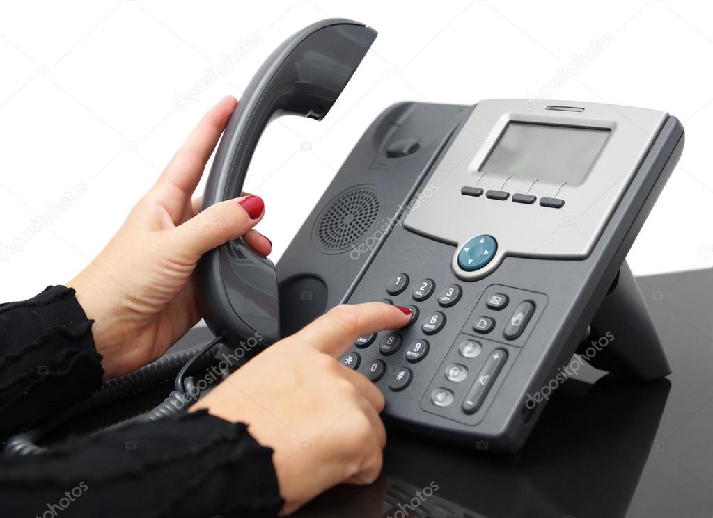 Female hand is dialing a phone number