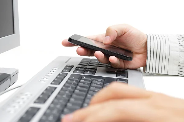 Geschäftsmann arbeitet im Büro mit Handy und Computer — Stockfoto