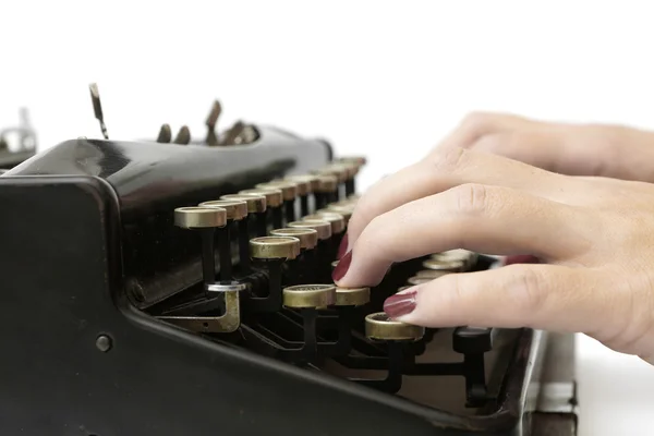 Primer plano de la mujer escribiendo con la vieja máquina de escribir Imagen de archivo