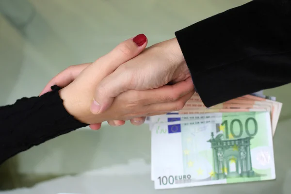 Biznesmeni i bizneswoman uścisk dłoni z pieniędzmi na biurku — Zdjęcie stockowe