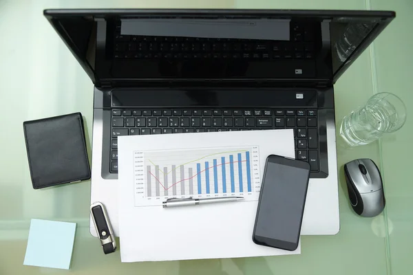 Moderner Arbeitsplatz mit Laptop und Zubehör auf gläsernem Schreibtisch — Stockfoto