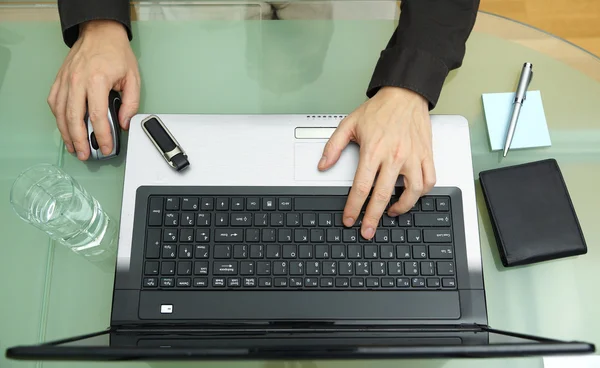 Jovem empresário trabalhando no escritório, sentado na mesa com lapto — Fotografia de Stock