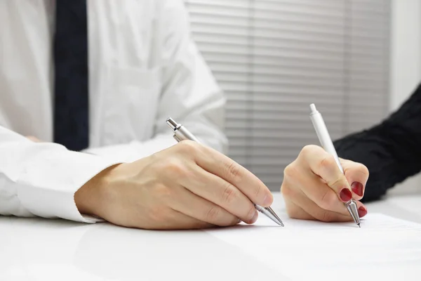 Business partners signing a document — Stock Photo, Image