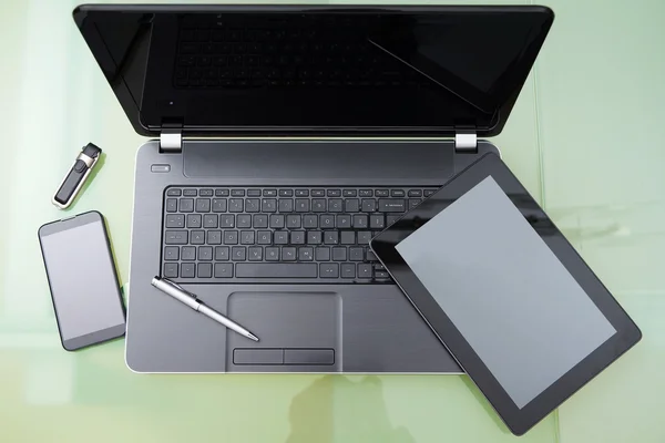 Laptop with tablet and smart phone on glass table — Stock Photo, Image