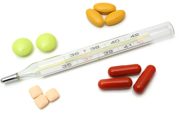 Illness concept with thermometer and tablets — Stock Photo, Image