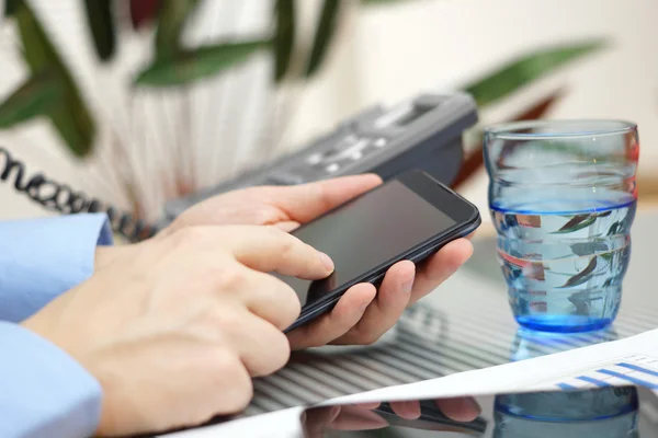 Businessman in office is talking on the phone and working with s — Stock Photo, Image