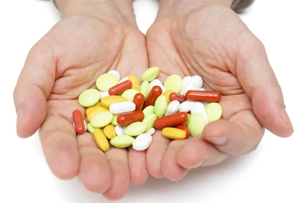 Hand med färgglada piller, över dosering med läkarbesök — Stockfoto