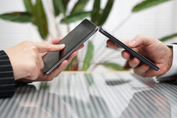 Woman and man transferring files from smart mobile phone to anot — Stock Photo, Image