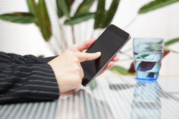 Affärskvinna använder smart telefon i ljusa kontor. grunt dep — Stockfoto