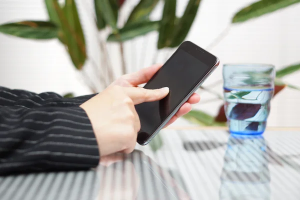 Zakenvrouw is met behulp van slimme telefoon in heldere kantoor. ondiepe dep — Stockfoto