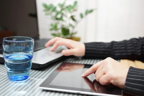 นักธุรกิจหญิงใช้แท็บเล็ตคอมพิวเตอร์และแล็ปท็อปในเวลาเดียวกัน — ภาพถ่ายสต็อก