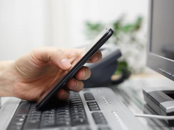 Бизнесмен работает в офисе с мобильным телефоном и компьютером — стоковое фото
