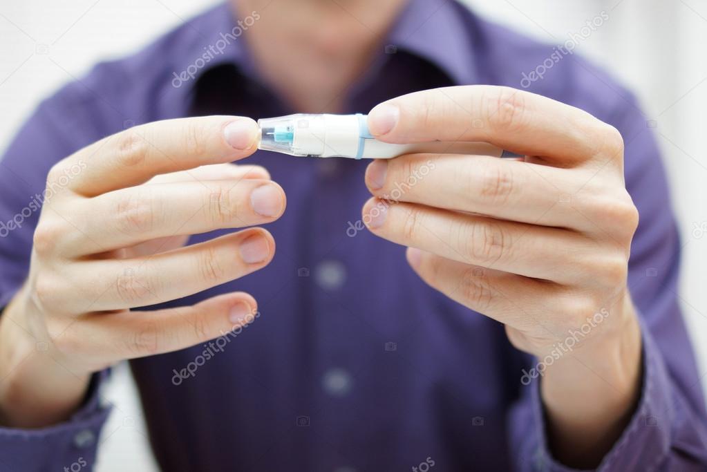 Closeup of young man using checking level of sugar in blood