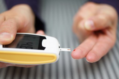 bir kan testi ile bir şeker ölçüm yapıyor diyabetli kadın
