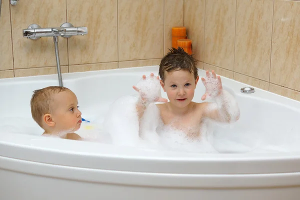 Two little boys having fun with water by taking bath in bathtub — Stock Photo, Image
