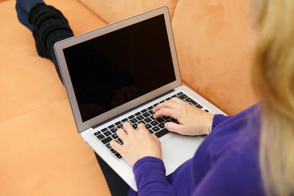 Fechar-se de mulher jovem usando laptop no sofá — Fotografia de Stock