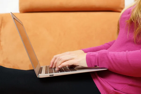 Side view of young woman using laptop on sofa — Stock Photo, Image