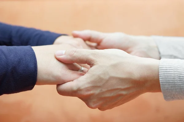 Mãos masculinas segurando as mãos da namorada. Conceito de cuidado e amor — Fotografia de Stock