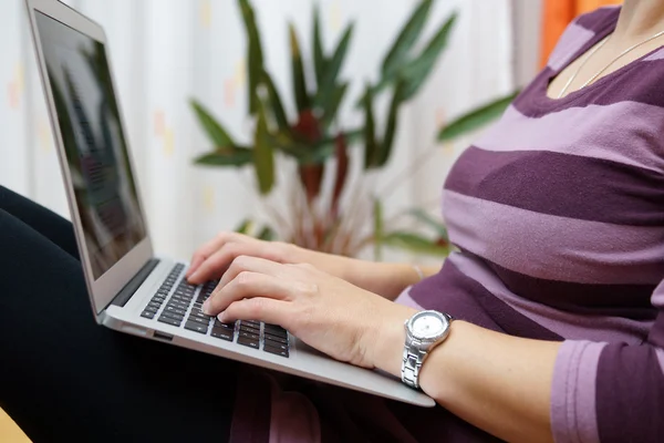 Donna digitando sul computer portatile, femmina utilizzando il computer seduto sul pavimento — Foto Stock