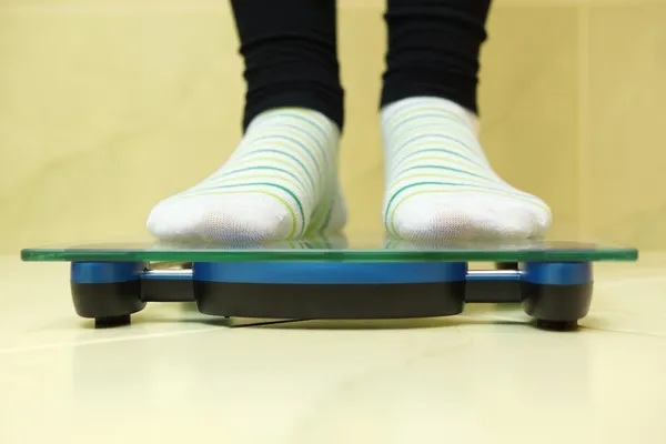 Woman standing on scales — Stock Photo, Image