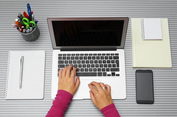 Ansicht von oben: Frau arbeitet mit Laptop im Büro oder zu Hause Stockbild