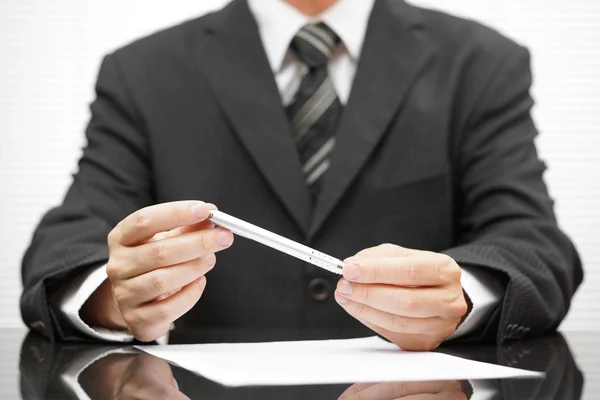 Empresário segurando caneta sobre o contrato proposto e pensando abou — Fotografia de Stock