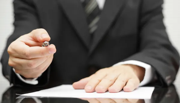 Businessman offering a pen to sign a contract — Stock Photo, Image