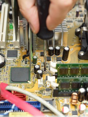 Teknisyen tornavida kullanarak bilgisayarı tamir ediyor.