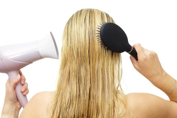 Woman using hairdryer  and  comb — Stock Photo, Image