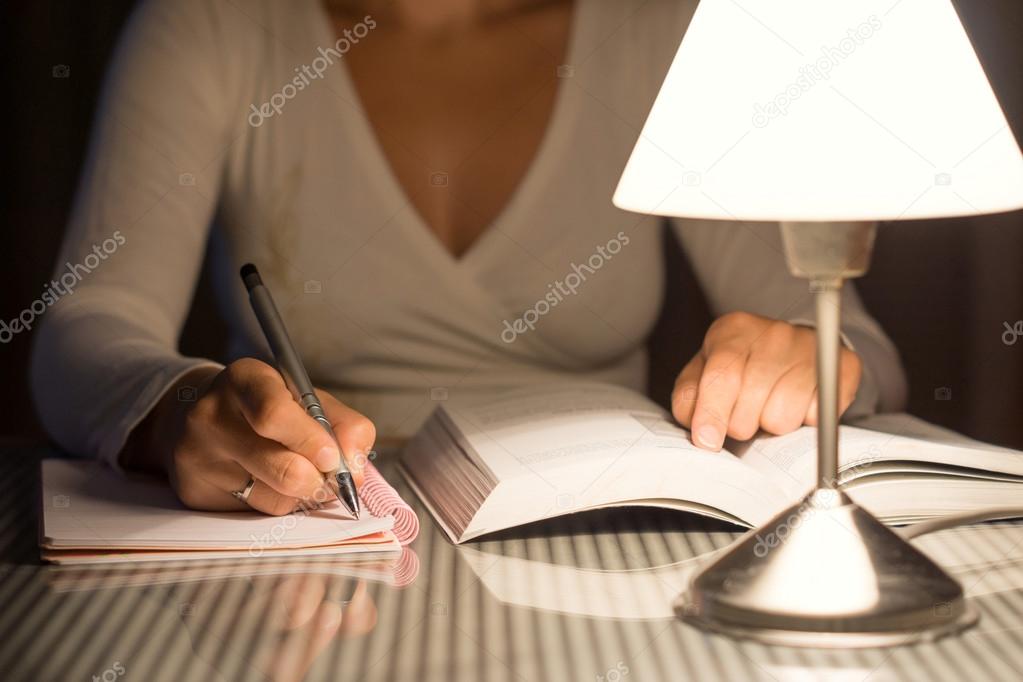 woman is studying and take notes late at night